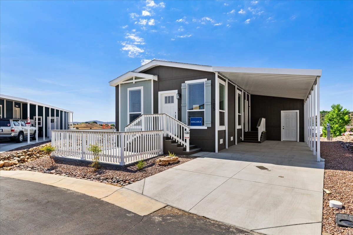 A move-in-ready manufactured home for sale at Orchard Ranch North Resort with a covered porch and mountain views.